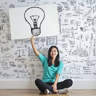 Woman Draw a Light bulb in White Board